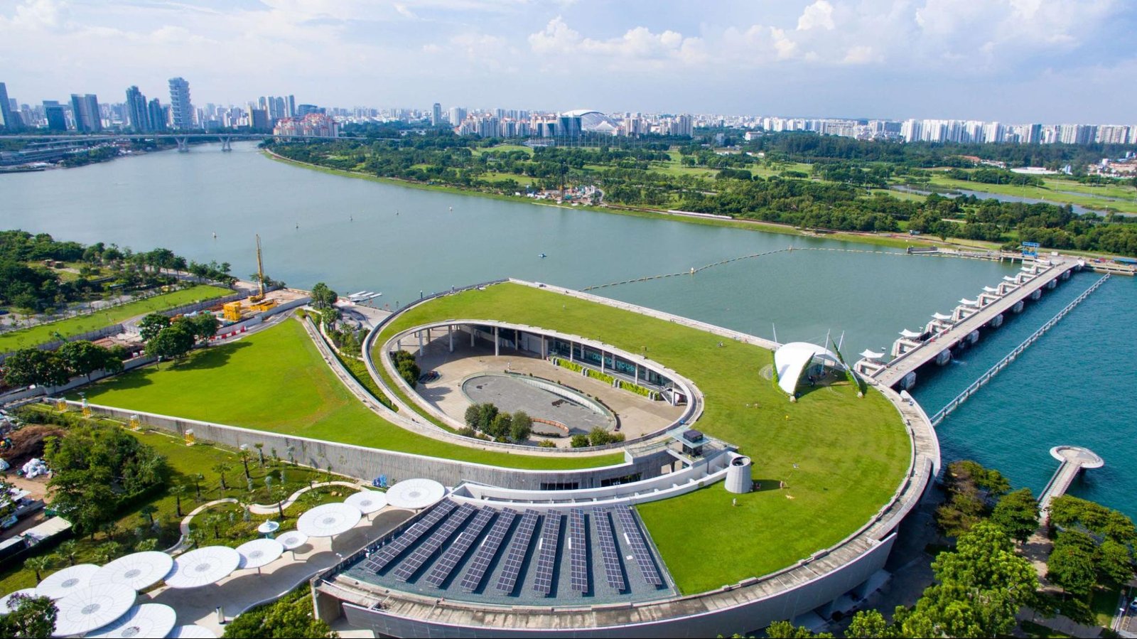 Vista aérea de Marina Barrage en Singapur con compuertas y áreas recreativas